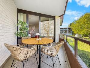 a patio with a table and chairs on a balcony at Design-Apartment mit Meerblick in Travemünde