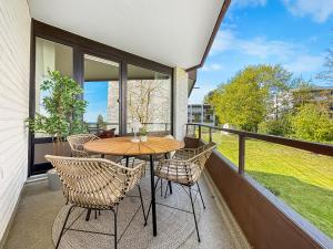 a patio with a table and chairs on a balcony at Design-Apartment mit Meerblick in Travemünde