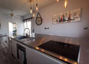a kitchen with a counter with a sink and a clock at Larnaca Breeze in Pyla