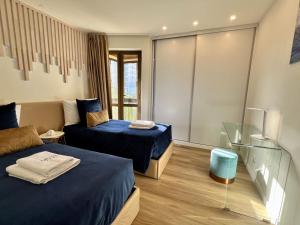 una camera d'albergo con due letti e un divano di Ocean Horizon a Funchal