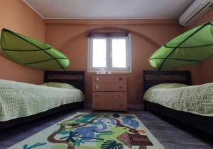 a bedroom with two beds and a window and a rug at Larnaca Breeze in Pyla