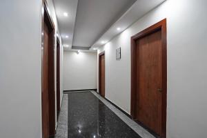 pasillo con puerta de madera en Hotel O Noida Stays, en Indirapuram