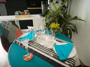 un tavolo blu con sopra dei bicchieri da vino di Les Treilles de Salies - Spa et sauna intérieur a Salies-de-Béarn Altre 16 foto