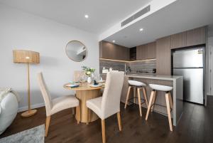 a kitchen with a table and chairs and a refrigerator at Starview Suite - Private Oceanview 2 Bedroom Apartment on the Star Residence Broadbeach, Free Carpark Included with your stay! in Gold Coast