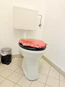 a bathroom with a toilet with a red lid at Terrassentraum für 2 in Vienna