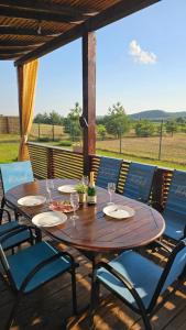 a wooden table with chairs and wine glasses on a porch at Green Hills Villa in Sakhnovka