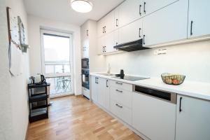 a kitchen with white cabinets and a large window at Vyskoč na hory in Nová Lesná