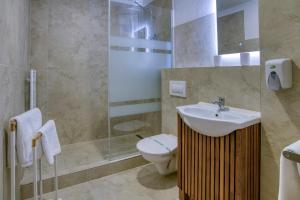 a bathroom with a toilet and a sink and a shower at Penzion Nevada in Dunajská Streda
