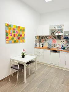 a kitchen with white cabinets and a white table and chairs at Chill and Grill for 2 in Vienna