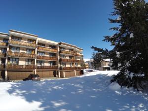 hotel w śniegu z drzewem w tle w obiekcie Alberti 5 w Davos