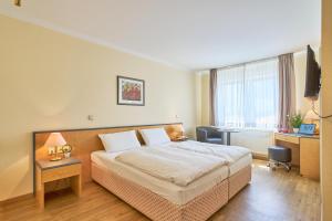 a hotel room with a bed and a desk at eXo Individual Hotel Waghäuseler Hof in Waghäusel