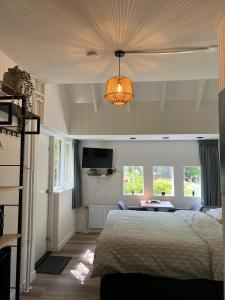 a bedroom with a bed and a table and windows at B&B De Dreef in Middelburg +16 photos