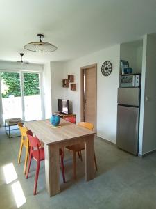 a kitchen with a table and chairs and a refrigerator at La CHANTERELLE in Mortagne