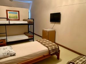 a room with two bunk beds and a flat screen tv at Hotel Carioca Palace in Pindamonhangaba
