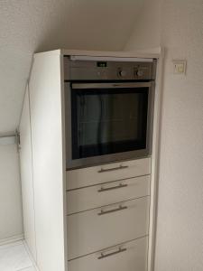Un centro de entretenimiento con televisión en una habitación. en 3-Zimmer-FeWo Hexenhäusle Bollschweil, en Bollschweil
