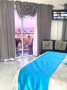 a bedroom with a bed and a large window at Royal Terrace Apto. II (Princess) in San Felipe de Puerto Plata