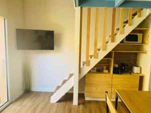 a living room with a staircase with a tv on the wall at Pavillon 4-6 couchages in Cap d'Agde