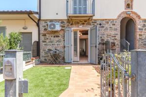 una casa con una puerta y un patio con césped en Appartamento - Il Gelso, en Lucignano