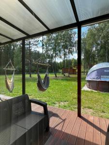 two hammocks hanging from a screened in porch at Cisza lasu in Kadłubówka +19 photos