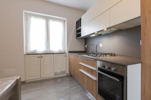 a kitchen with a stove top oven next to a window at Casa Gigi in Vercana +2 photos