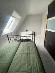 Un dormitorio con una gran cama verde en un ático en 3-Zimmer-FeWo Hexenhäusle Bollschweil, en Bollschweil