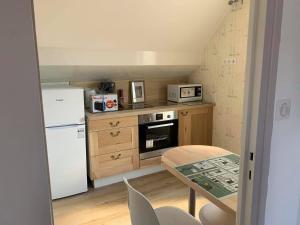 eine kleine Küche mit einem Tisch und einem weißen Kühlschrank in der Unterkunft Bristol Manor N20 terrasse cuisine et chambre in Néris-les-Bains + 17 Fotos
