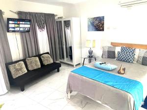 a bedroom with a bed and a couch at Royal Terrace I (Queen ) in San Felipe de Puerto Plata