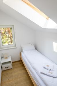 a small bedroom with a bed and a window at Stylowe Osiedle Wieleń - domy wakacyjne in Wielen Zaobrzanski