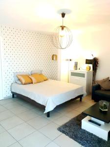 a bedroom with a bed and a chandelier at Le Contemporain - Wifi - Proche centre ville in Lyon