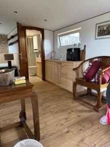 a living room with a table and a kitchen at Beautiful 1 bedroom village house among fields 