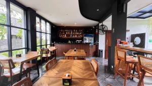 a restaurant with wooden tables and chairs and windows at Baliem Resort Jimbaran in Jimbaran