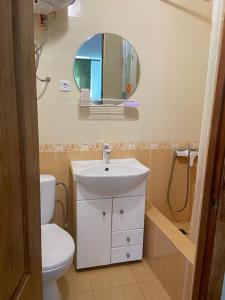 a bathroom with a sink and a toilet and a mirror at Затока жилье центр въезд со стороны Белгород-Днестровского in Zatoka