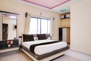 a bedroom with a large bed and a large window at Hotel O Datta Nagar Formerly Baba Sai in Shirdi