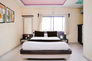 a bedroom with a large bed and a window at Hotel O Datta Nagar Formerly Baba Sai in Shirdi +23 photos