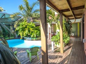 a house with a swimming pool and a wooden deck at La Villa du Patio Parenthèse familiale Piscine 4 in Saint-Pierre