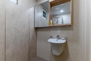 a bathroom with a sink and a mirror at Namhae Frankfurt Pension in Namhae +47 photos