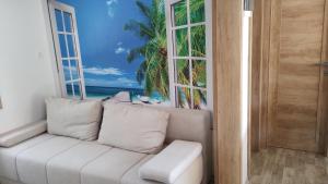 a white couch in a room with a window at Sunrise Wellbeing mobile home for mindful, vegetarian, active rest, just 35 meters from the sea in Grebaštica