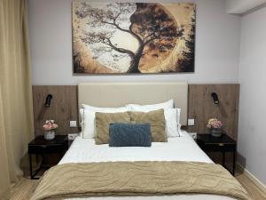 a bedroom with a large bed with a painting above it at Meu Refugio Apartamento in Silveira