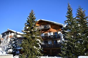 a ski lodge with trees in front of it at Catered chalet ideal location centre of Alpe d'Huez - 4 en-suite bedrooms - sauna - private home cinema - 10 people in L'Alpe-d'Huez