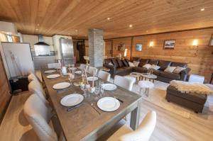 a dining table and chairs in a living room at Catered chalet ideal location centre of Alpe d'Huez - 4 en-suite bedrooms - sauna - private home cinema - 10 people in L'Alpe-d'Huez