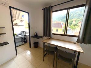 een eetkamer met een tafel en een raam bij Patong Canal Villa 305 in Patong Beach