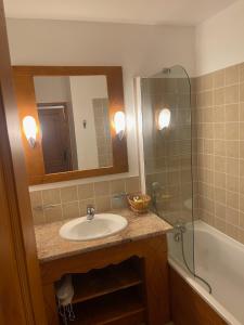 a bathroom with a sink and a mirror and a tub at Cozy studio 3 guests, private terrace, inside pool, spa, luxurious residence, ski-in ski-out in Bourg-Saint-Maurice