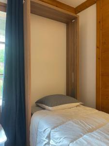 a bedroom with a bed with a blue curtain at Cozy studio 3 guests, private terrace, inside pool, spa, luxurious residence, ski-in ski-out in Bourg-Saint-Maurice +9 photos
