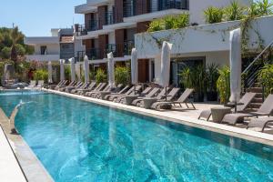 a swimming pool with chairs and a hotel at Uliv Apart Hotel & SPA in Ayvalık