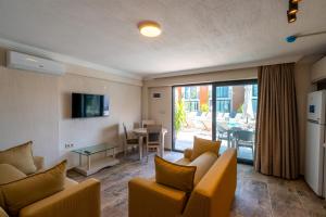 a living room with couches and a table and a dining room at Uliv Apart Hotel & SPA in Ayvalık