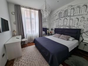 a bedroom with a bed and a wall with buildings at Arena Design Apartments with FREE Private Parking and with a terrace in Pula