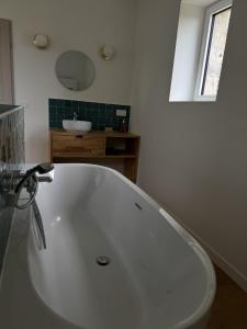 a white bath tub in a bathroom with a sink at Belle demeure de vacances in Meyronne