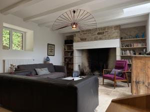 a living room with a couch and a fireplace at Belle demeure de vacances in Meyronne
