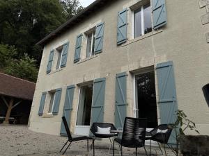 a group of chairs and a table in front of a building at Belle demeure de vacances in Meyronne
