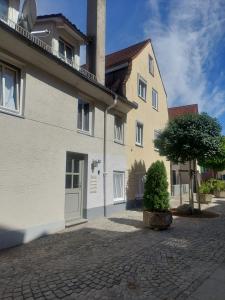 a white building with a tree in front of it at Ferienwohnung im schönen Allgäu in Kaufbeuren